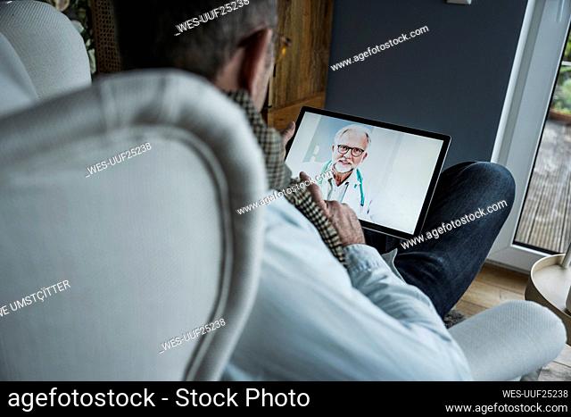 Doctor advising patient on video call through tablet PC at home