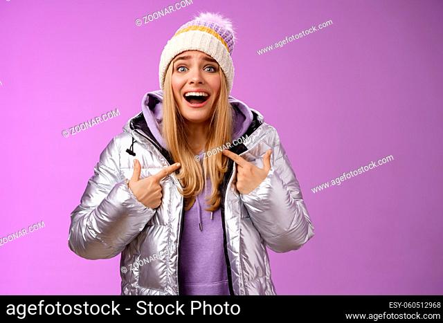 Surprised happy smiling joyful attractive woman pointing herself satisfied picked was chosen winner standing excited in silver shiny jacket winter hat cannot...