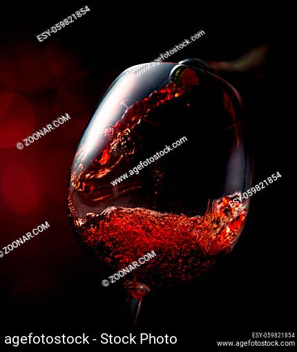 Wine pouring in wineglass on a vinous background