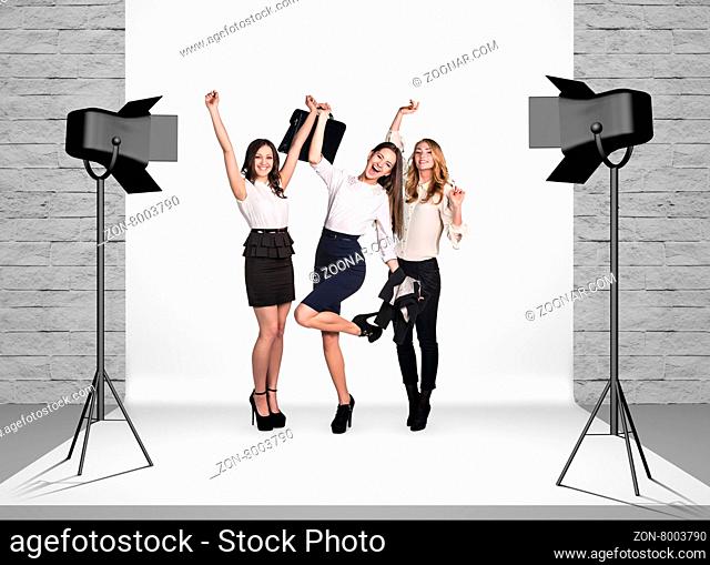 Business women in photo studio room with white cloth and spotlights