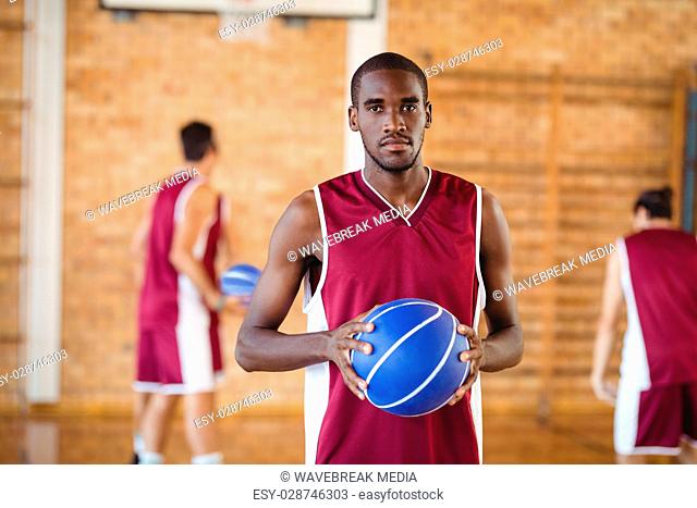 Confident basketball player holding a basketball
