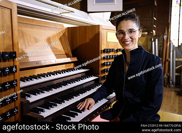 PRODUCTION - 23 August 2021, Schleswig-Holstein, Schleswig: Mahela Reichstatt, cathedral organist, sits at the console of the great organ in Schleswig Cathedral