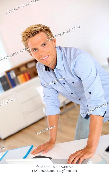 Portrait of smiling attractive young man in office