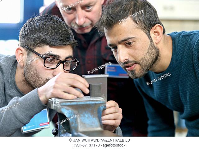 Instructor Frank Blobel (c) watching Shiar Ali (l) and Ibrahim Ezzedin (r) from Syria during their internhip at the metal workshop of the Chamber of Crafts in...