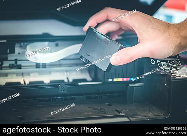 Putting new printer cartridge into the printer, inkjet