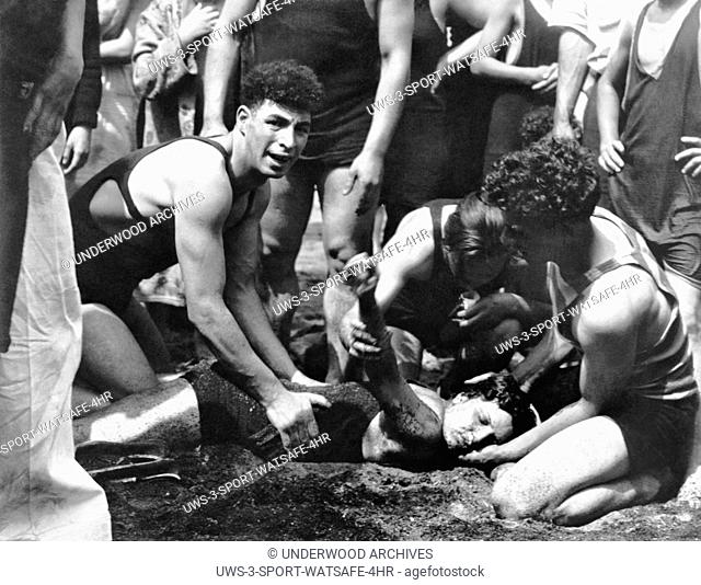 Farmer's Dock, New York: c. 1928 A lifeguard resuscitating a young woman swimmer he had rescued after she went down for the third time during a hot Memorial Day...