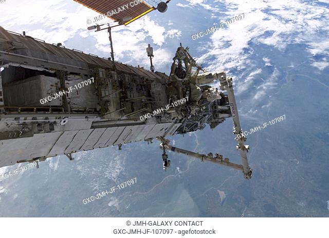 Backdropped by a blue and white Earth, the new P3P4 truss and the Canadarm2 on the International Space Station are featured in this image taken by an Expedition...
