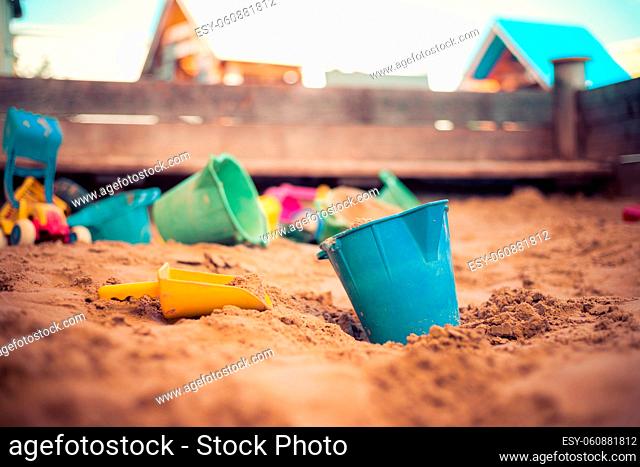 Children plastic toys in the sand box. Dirt bucket, selective focus