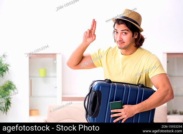 Young man holding passport and suitcase preparing for the trip