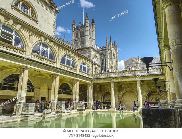 The Great Bath situated beneath the Terrace of the Roman Baths and Bath Abbey towering above the Baths, Bath, Somerset, England, UK