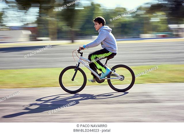 Hispanic boy riding bicycle