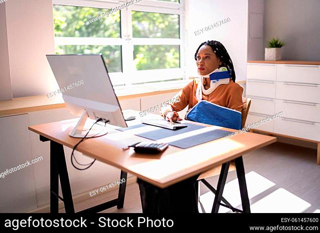 Portrait Of Disabled Mature Businesswoman On Wheelchair Using Computer At Office
