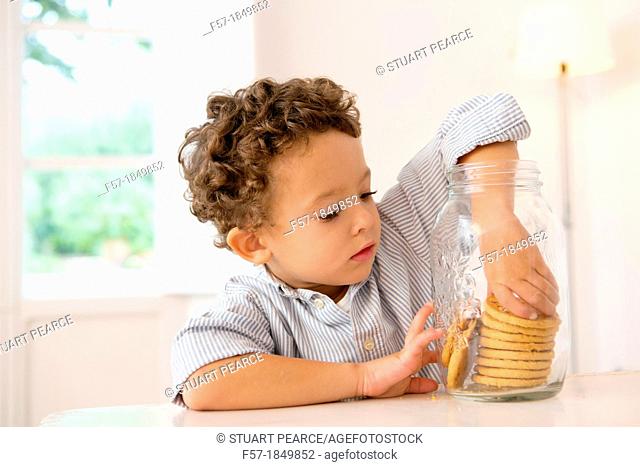 Four year old boy with his hand in the cookie jar
