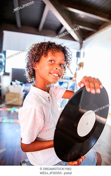 Portrait of happy young dj with vinyl record