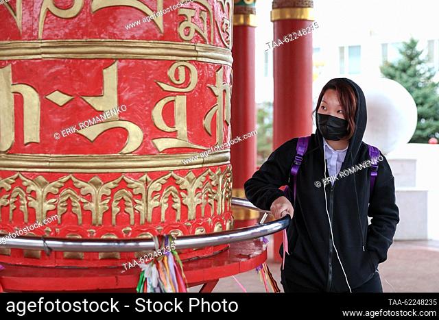RUSSIA, ELISTA - SEPTEMBER 16, 2023: A woman at a prayer wheel at the Burkhan Bakshin Altan Sume (Golden Abode of the Buddha Sakyamuni)