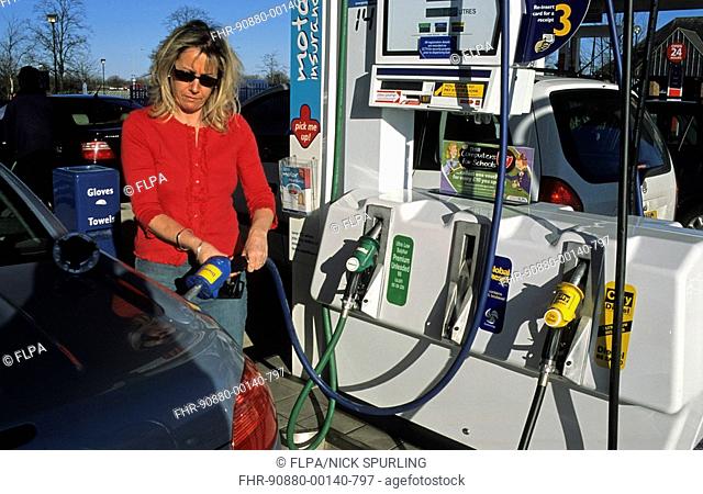 Woman filling car with 'Global Diesel', containing biodiesel, at supermarket petrol station, Hatfield, Hertfordshire, England