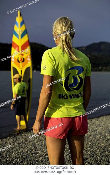 Model release yes. MacRae Wylde and Eva DeWolfe getting ready to paddle board on the Columbia River, Oregon. Hood River. USA. Summer