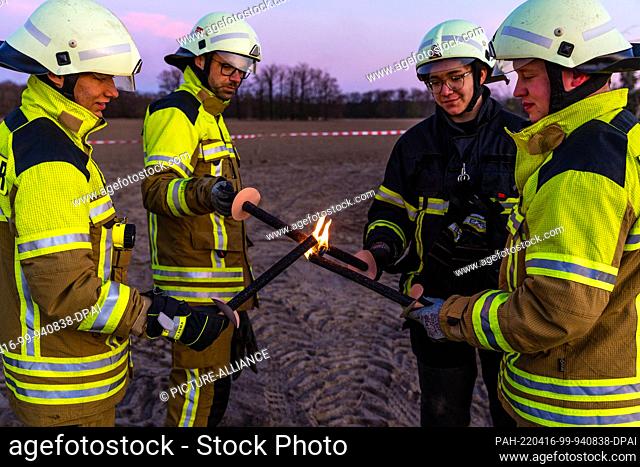 16 April 2022, Brandenburg, Cottbus: Comrades of the fire department light torches. With them they are about to light the Branitz Easter fire