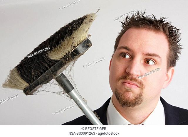 young business man with dusty broom