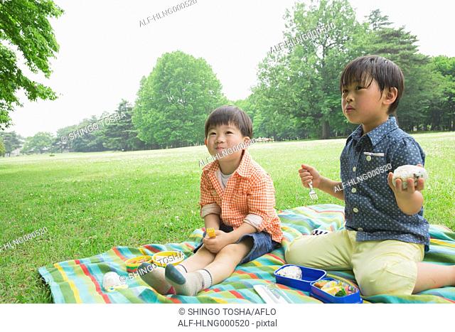 Japanese kids having picnic in a park