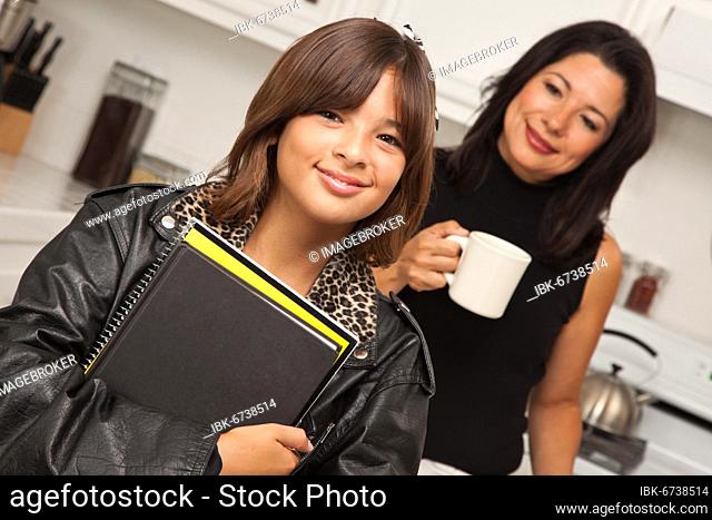Pretty hispanic girl and mother getting ready for school in the kitchen