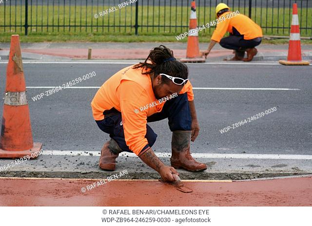 KAITAIA, NZ JAN 23:Road workers use finishing trowel tool on Jan 23 2014.The Road Maintenance crew has the responsibility for the day-to-day maintenance needs...