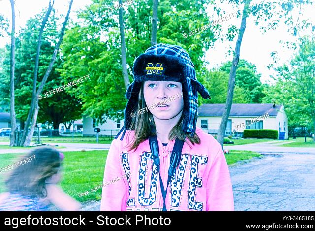 Unhappy girl with Michigan University hat and pink hoody in Indianapolis, Indiana, USA