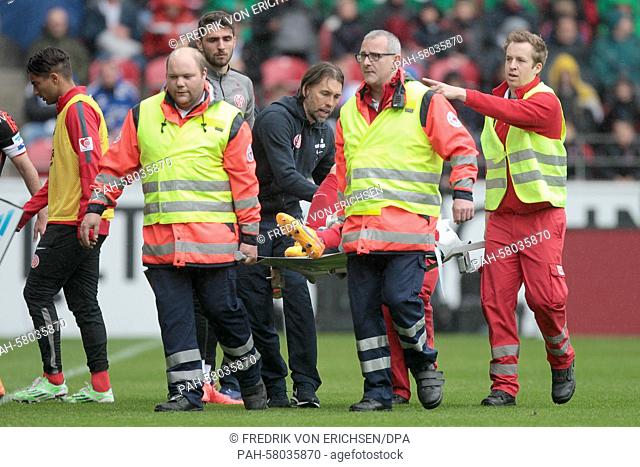 Mainz' Elkin Soto is stretched off the pitch while Mainz coach Martin Schmidt (4-L) hurries over to see him during the German Bundesliga soccer match between 1