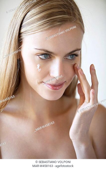 donna si applica la crema per il viso