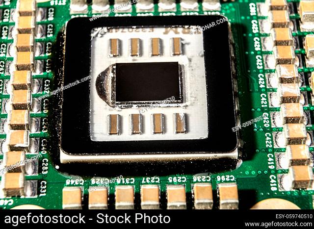 Small electronic components on green circuit board macro closeup