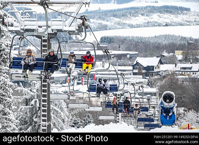 01 December 2023, North Rhine-Westphalia, Winterberg: Leisure sports enthusiasts sit in a chairlift. The winter sports season begins in the ski resorts around...