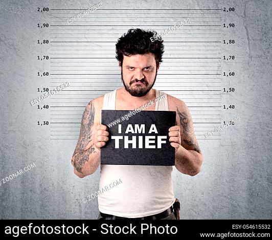 Caugth offender in front of a wall with table in his hand