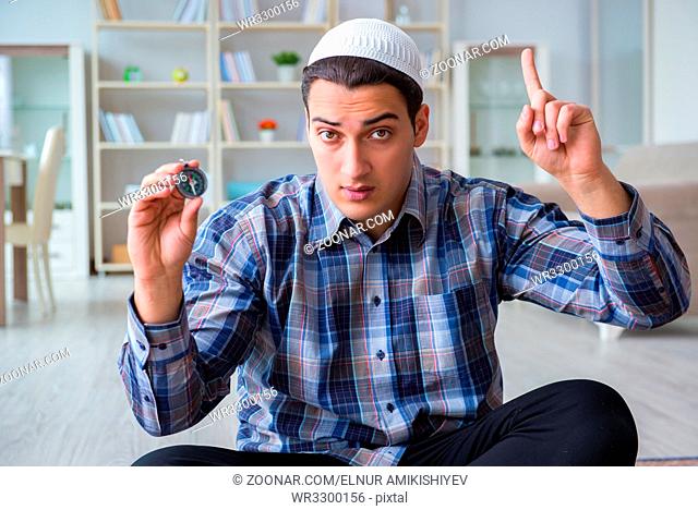 Young muslim man praying at home