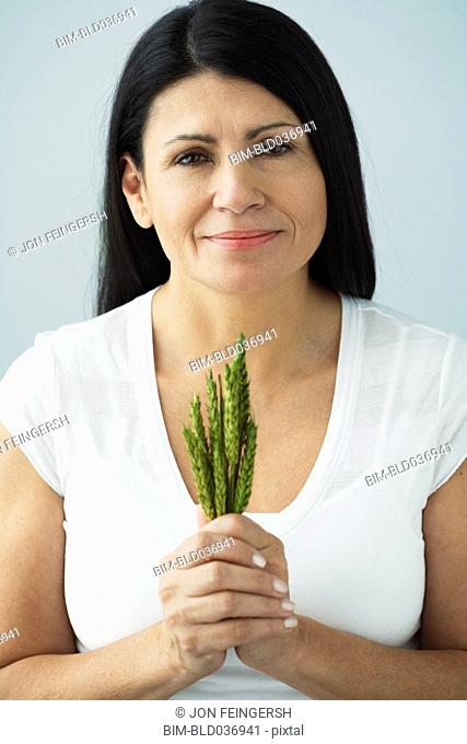 Hispanic woman holding bunch of grain