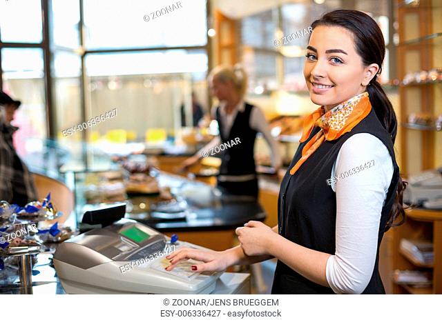 Shopkeeper and saleswoman at cash register or cash desk