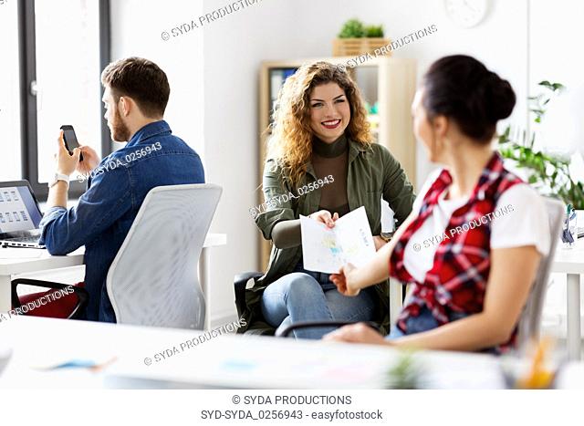 female office workers giving each other papers