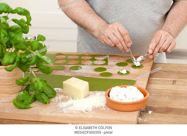 Man preparing green ravioli with ricotta