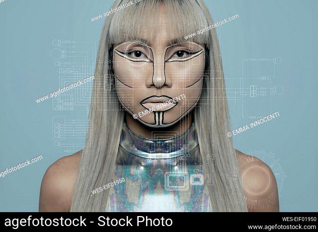Robotic young woman with blond bangs against blue background