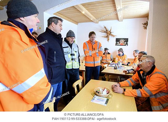 12 January 2019, Bavaria, Wolfratshausen: Markus Söder (CSU, 2nd from left), Minister President of Bavaria, is talking to the emergency services about their...