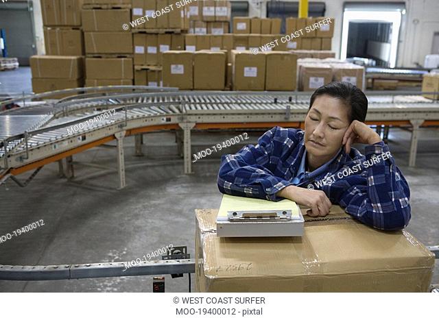 Woman asleep in distribution warehouse