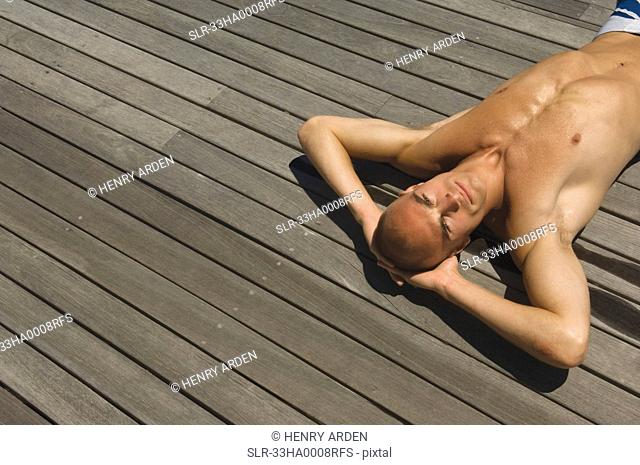 Man laying on wooden deck