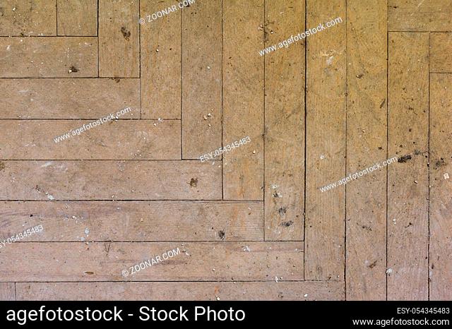 A close-up of an old faded parquet covered with dust and dirt. Result of repair. Cleaning and cleaning required