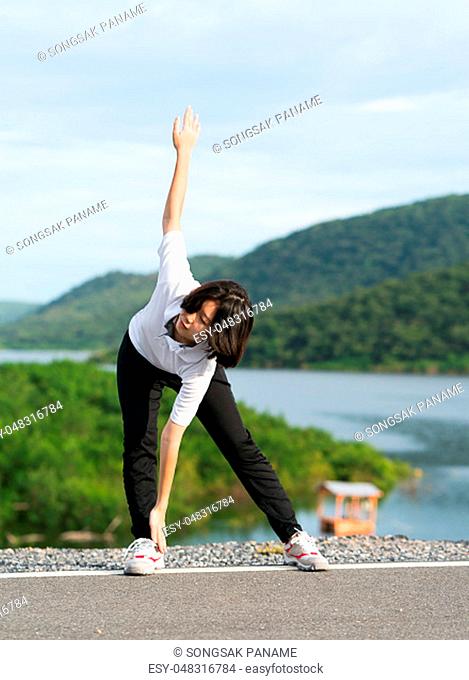 Fitness and lifestyle concept - Young asian woman short hair doing exercising outdoor and warm up preparing for jogging