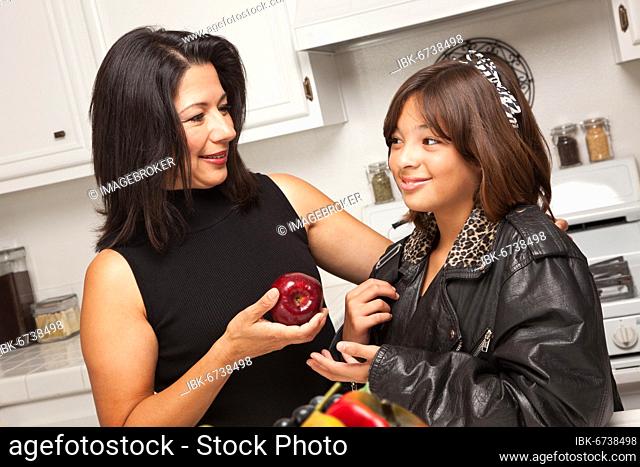 Pretty hispanic girl and mother getting ready for school in the kitchen