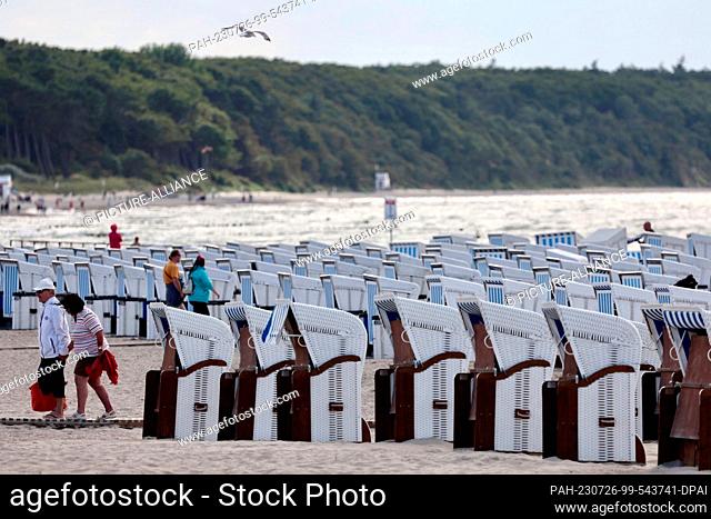 26 July 2023, Mecklenburg-Western Pomerania, Rostock: Empty beach chairs stand on the Baltic coast in Warnemünde. Stormy