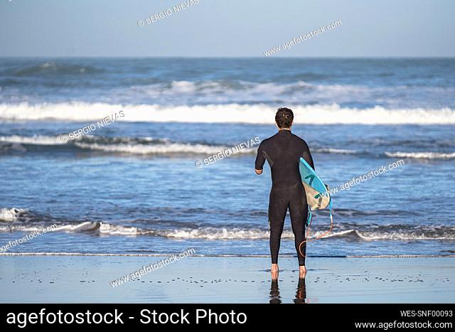 Handicapped surfer with surfboard at beach
