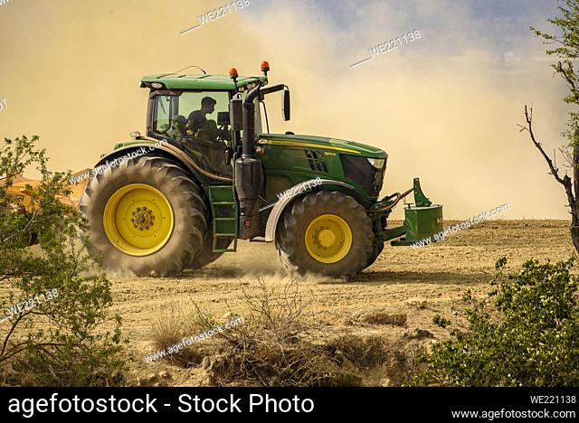 Tractor working to prevent the advance of the 2022 Pont de Vilomara wildfire with a cloud of dust due to extreme drought (Bages, Barcelona, Catalonia, Spain)