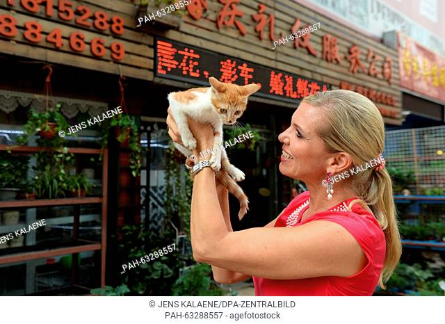dpa-Exclusive - Maja Synke, Princess of Hohenzollern, holds a small cat in her hand as she visits the flower market in Shanghai, China, 31 August 2015