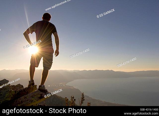 A Hiker Gazes Across Lake Tahoe at Sunset From a Mountaintop