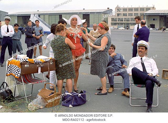Some costumers dressing up Austrian actress Senta Berger on the set of the film Treasure of San Gennaro. In the foreground, Italian actor